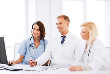 doctors looking at computer on meeting