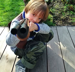 Muurstickers boy playing with gun © gmddl