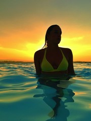 woman in pool at sunset