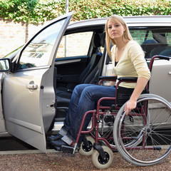 Frau mit Rollstuhl steigt in Auto