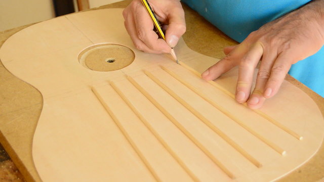Luthier working in a guitar harmonic cover