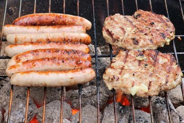 Bratwürste und Frikadellen auf Holzkohlegrill