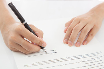 Female hand signing contract.