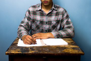 Young man writing at desk