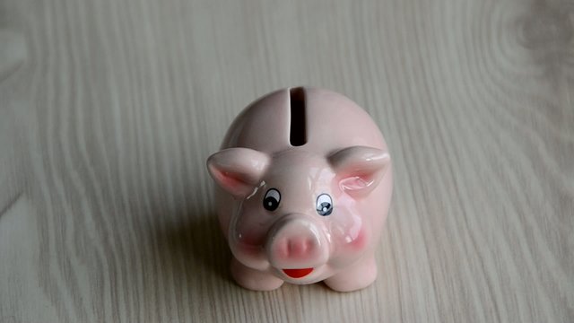 Una chica poniendo dinero en una hucha