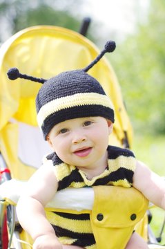 funny baby in bee costume on baby carriage