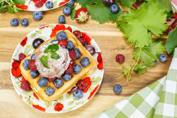 Belgian waffles with fresh berry fruits ,grapes and cream