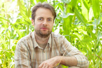 Happy smiling caucasian farmer in front of corn field © pinkyone