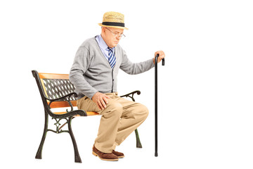 Senior man with a cane sitting on a bench
