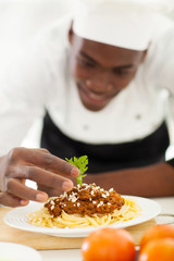 african chef garnishing spaghetti