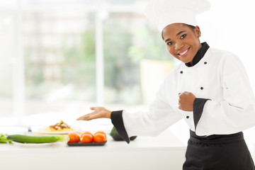 african female chef presenting vegetables
