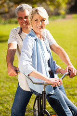 senior couple on a bicycle outdoors