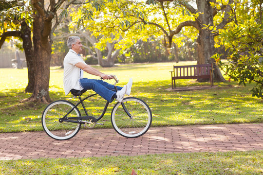 playful senior man riding bicycle