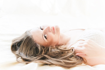 Fototapeta premium brown-haired woman lying on her duvet in her bedroom
