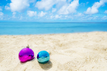 Fototapeta na wymiar Two Christmas balls on the beach - holiday concept