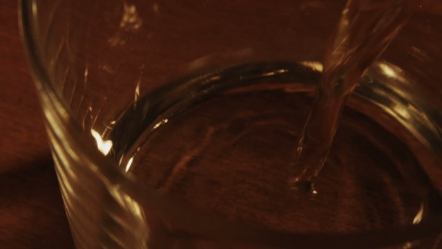 Whiskey poured into glass in slow motion
