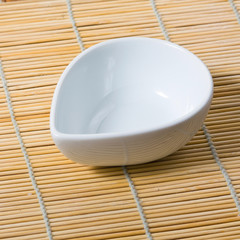 white bowl and bamboo mat