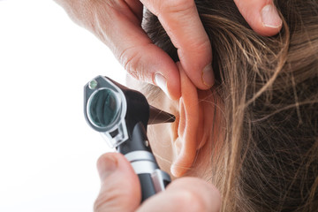 Examining ear with otoscope - obrazy, fototapety, plakaty
