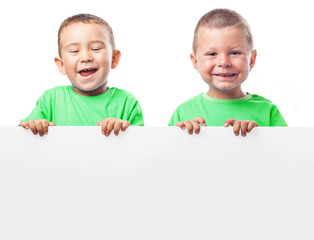 children behind a billboard with a green t-shirt on a white back