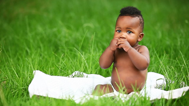 Cheerful African American baby smiling in park