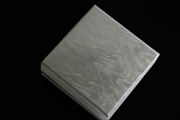 square box with silver lid against black background