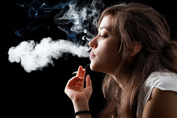 Woman Smoking a Cigarette on Black Background - obrazy, fototapety, plakaty