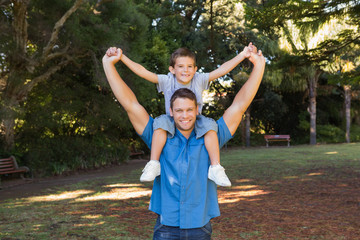 Obraz premium Father holding his son on shoulders