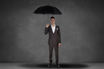 Obraz premium Business man holding an umbrella