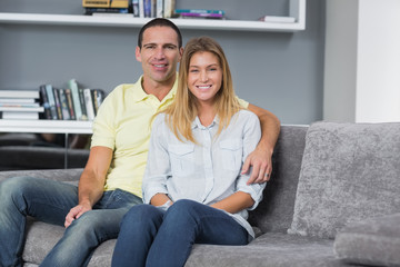 Obraz premium Happy young couple sitting on their couch