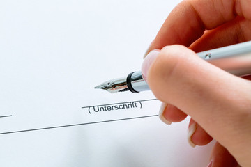 Hand mit Füllfeder bei Unterschrift