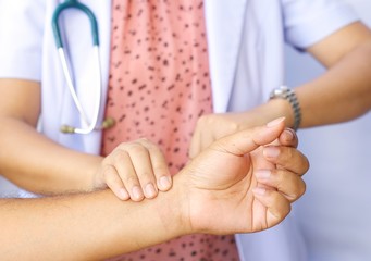 female doctor checking patient heartbeat