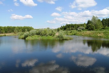 Fototapeta na wymiar B1louds are reflected in the lake