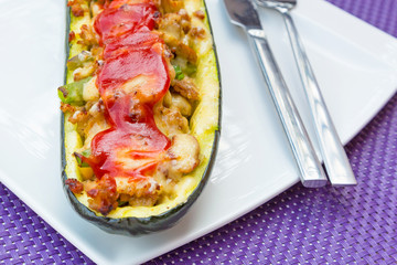 Zucchini halves stuffed with minced meat, vegetables and cheese