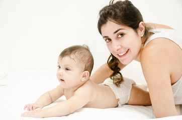 Obraz na płótnie Canvas Mother and baby in white bedroom.
