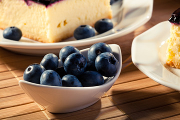 Blueberries served with cheesecak and a cap of coffee