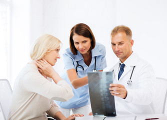 doctors with patient looking at x-ray