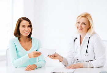 doctor giving prescription to patient in hospital