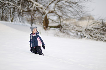 Fototapeta na wymiar Little girl having fun on winter day