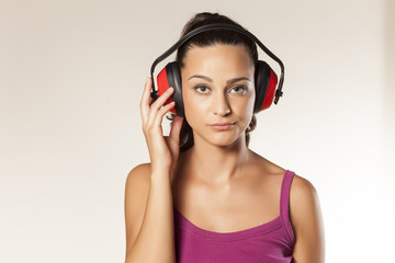 beautiful wierd young brunette posing with anti loud headset