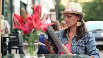 Woman reading menu in cafe, steadicam shot