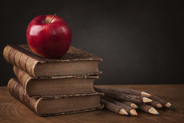 Stack of books and red apple