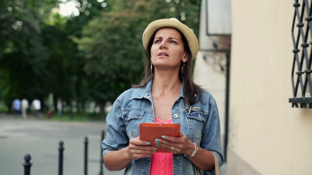 Female tourist with tablet computer in the city