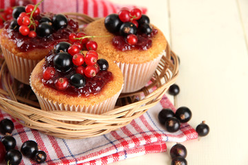 Tasty muffins with berries on white wooden table