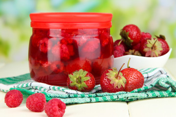 Home made berry jam on wooden table on bright background
