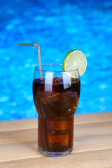 Tasty cocktail on swimming pool background