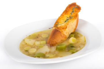 Leek soup bowl over white background