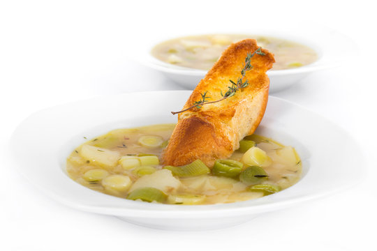 Leek soup bowl over white background