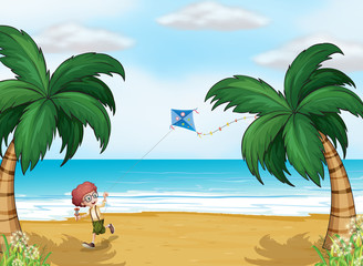 A young boy playing with his kite at the beach