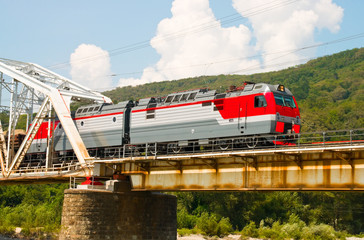 Train rides over bridge across mountain river