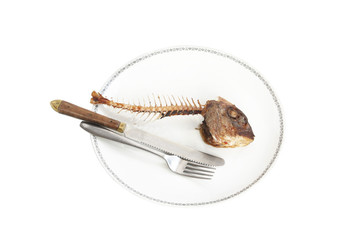 Fototapeta premium Fish skeleton on the plate - symbol for food shortage